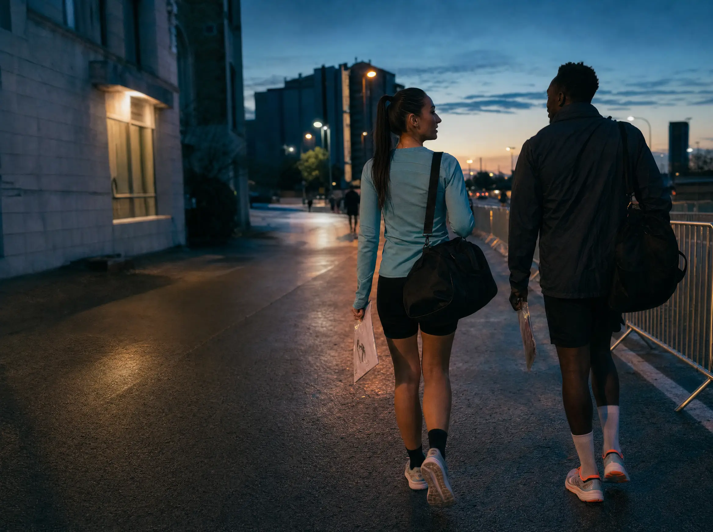 Adult runners walking toward a city race start at dawn